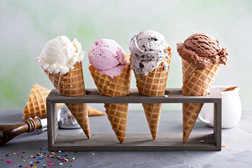 four waffle cones in stand with ice cream