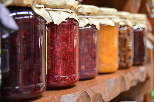jars of jam lined up on a shelf