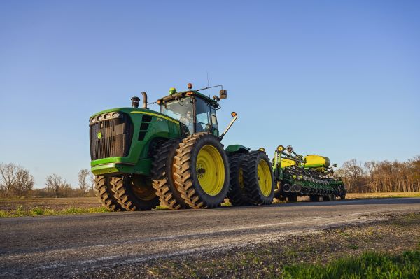 A John Deer tractor spraying the field during the day.